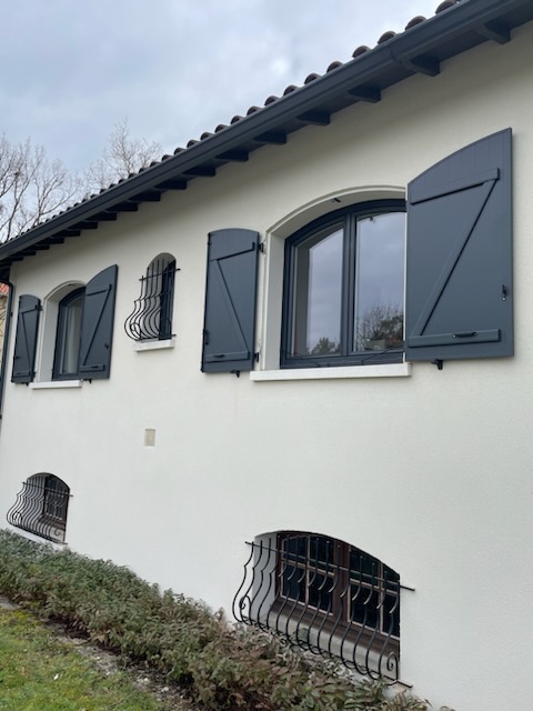 Façade avec des volets en menuiserie et des fenêtres modernes.